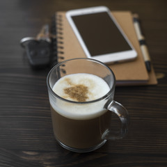Cup of coffee, organizer and mobile phone on desk