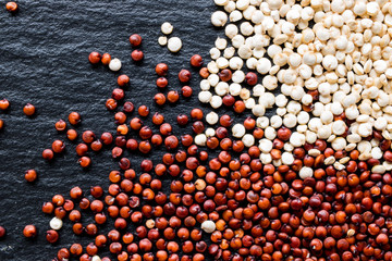 Quinoa seeds on black slate background, macro, top view