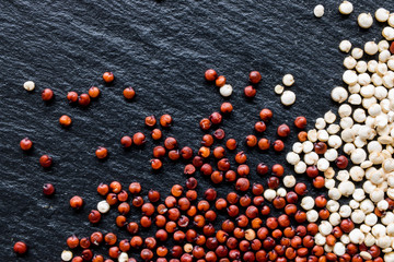 Quinoa seeds on black slate background, macro, top view