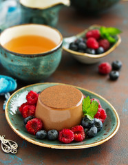 Delicious home-made chocolate dessert Panna cotta. Cream-caramel, caramel custard, with raspberries and blueberries.