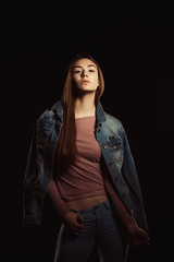 Fashionable young woman with natural makeup and perfect skin wearing trendy jeans jacket