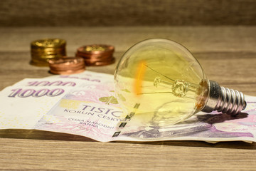 Lit European bulb placed on Czech money