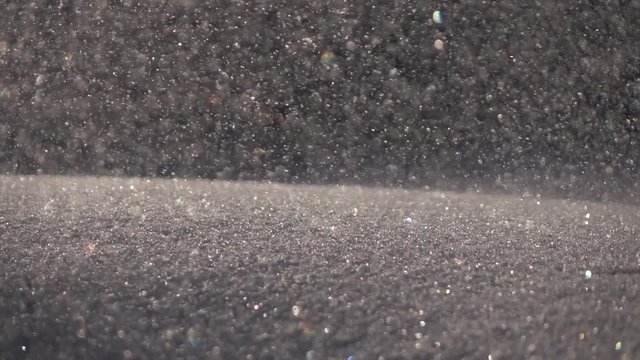 Snowdrift in sunshine close up with dramatic entrance of snow clot. Winter sunny lyric scene with glittering colorful snowflakes and rolling snowball in slow motion. Sparkling snowy macro background.