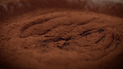 closeup macro of chocolate texture cacao powder with a cream texture under and spoon take a part of it