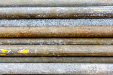 Mental scaffold pipe stack together on scaffold plank wood shelve with blue, green and yellow mark at the tip for build the temporary structure.