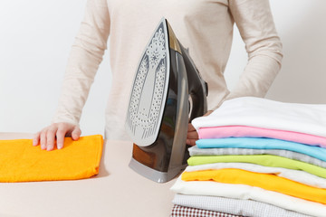 Close up cropped portrait housewife in light casual clothes ironing family clothing on ironing...