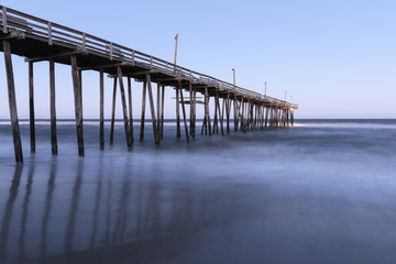 Fototapeta premium Długa ekspozycja oceanu i molo o zachodzie słońca