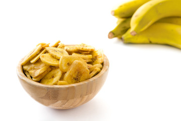 Banana chips in wooden bowl isolated on white background

