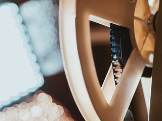 Front view of an old-fashioned antique Super 8mm film projector, projecting a beam of light in a...