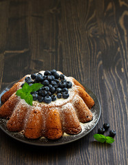 Vanilla cake (gugelhupf) with blueberries. dark background.