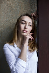 Romantic young woman in white shirt posing at the passage