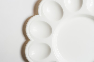 Minimalistic white background of part of the round plastic plate for eggs on a blank background.