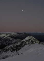 The light of the full moon illuminates the mountains