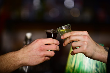 Friends drink shot or liqueur and cheers. Party concept.