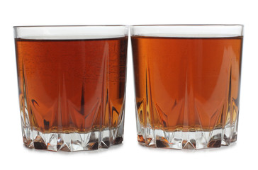 Glass jars with whiskey and ice on white background