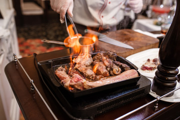 Hand of grilling some meat and meat ball on hot flame..