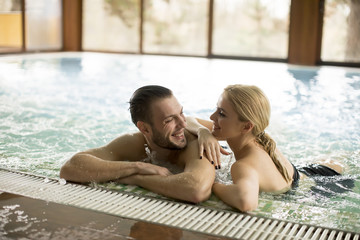 Loving couple relaxing in the pool at spa