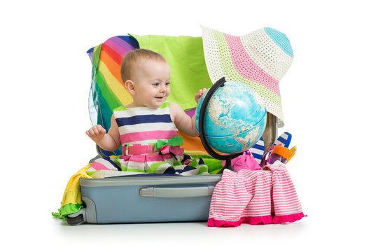 Adventure concepts. Baby preparing for the journey. Child sits in suitcase and looks at globe.