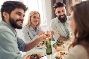 Group of happy young friends eating and having fun at home