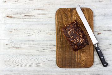 Fresh rye bread on the French recipe on cutting board with knife