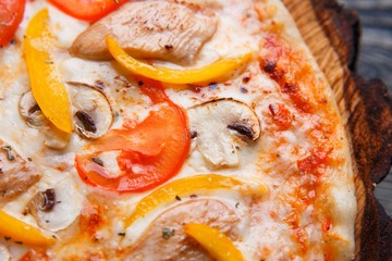 Food background, pizza texture. Close up of appetizing pizza with tomato, chicken, paprika and mushrooms, macro