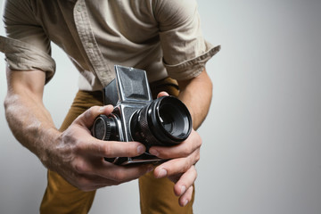 Fashion Photographer with an old film camera in hand while working in studio.