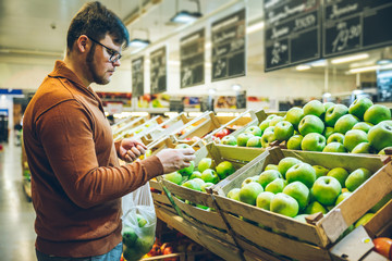 man choose apples at market.