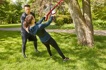 Frau bei Suspension Sling Training im Park