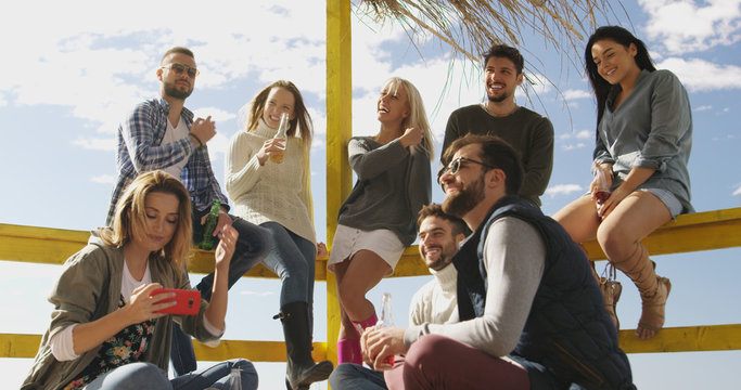 Group of friends having fun on autumn day at beach