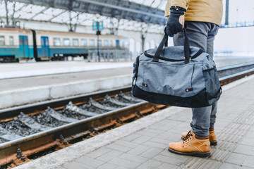 man hold bag close up on railway station