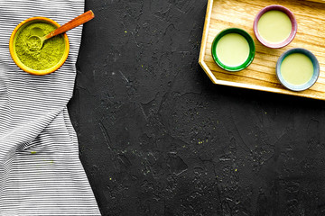 Japanise tea ceremony with matcha tea. Bowl with powder and cups with beverage on tablecloth black background top view copy space