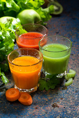 glasses of fresh vegetable juice from carrots, tomatoes and herbs, vertical