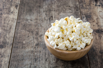 Popcorn in bowl on wooden table background. Copyspace