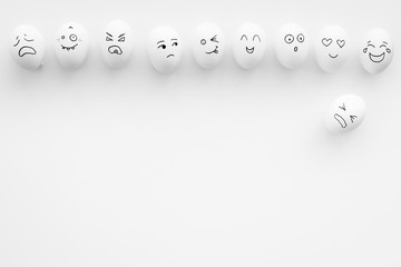 Basic emotions concept. Faces drawn on eggs. Happy, smile, sad, angry, in love. White background top view copy space