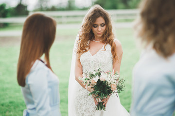 Bride with bridesmaids in the park on the wedding day