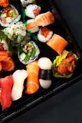 fresh traditional Japanese sushi with scallops, tuna, shrimp, mix rolls, octopus sashimi, salmon, tuna, top view. food delivery. A large set of sushi, rolls, sashimi in the package.