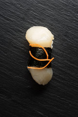 fresh traditional japanese sushi with scallop on a black background top view. delivery of food from a Japanese restaurant.
