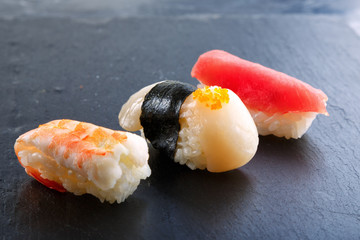 fresh traditional Japanese sushi with scallop, tuna, shrimp on a black background top view. delivery of food from a Japanese restaurant.