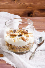 muesli with natural yoghurt, nuts and dried fruits in a glass jar