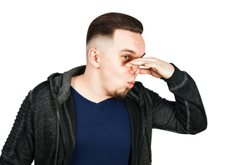 Closeup portrait of handsome guy, businessman closing nose, something stinks. Negative human face expressions, emotions, feelings, reaction, attitude, behavior, perception