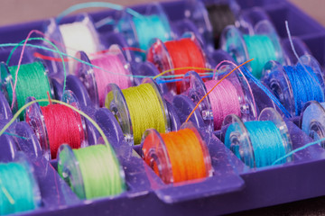 colored cotton thread on yarn bobbins in a box