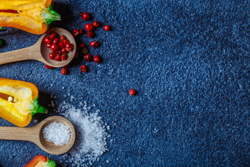 yellow and orange pepper spoons with pepper and salt