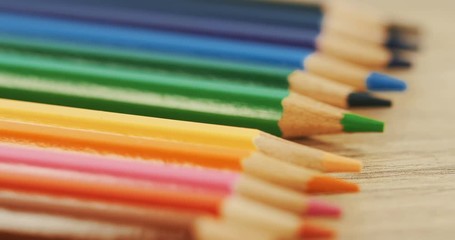 Close up of the colourful pencils lying on the desk in the line and one taking away. Macro. Top view - Powered by Adobe
