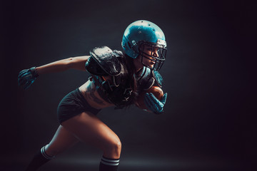 Sexual sportive woman running with rugby ball and screaming aggressively.