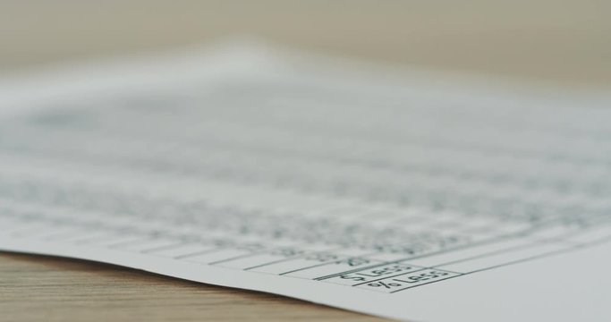 Macro shooting of the chart with numbers, currencies and per cents on the table. Close up of the document and focus zooming in and out