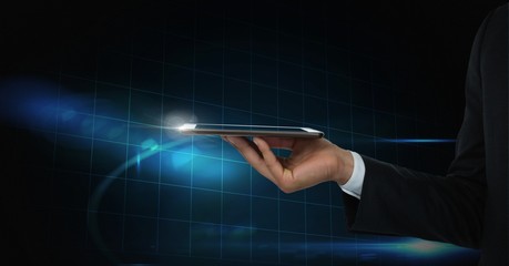 Hand holding tablet with blue technology background