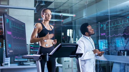Man Wearing Brainwave Scanning Headset Sits in a Chair while Scientist Adjusts the Device. In the...