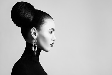 Retro style black and white fashion portrait of elegant female model with hair bun hairstyle and...