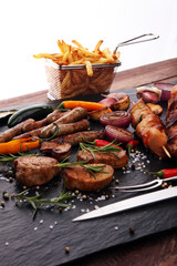 Assorted delicious grilled meat with vegetable and frites on a barbecue