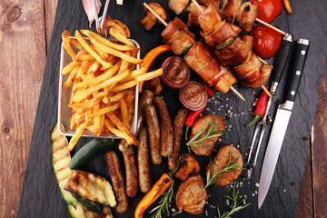 Assorted delicious grilled meat with vegetable and frites on a barbecue